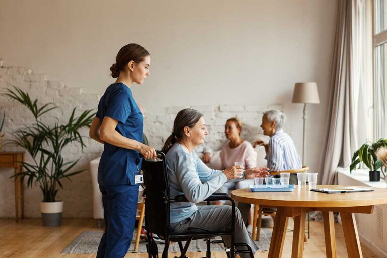 Two older adults sitting at a table with papers, calmly discussing documents in a comfortable, sunlit living space.